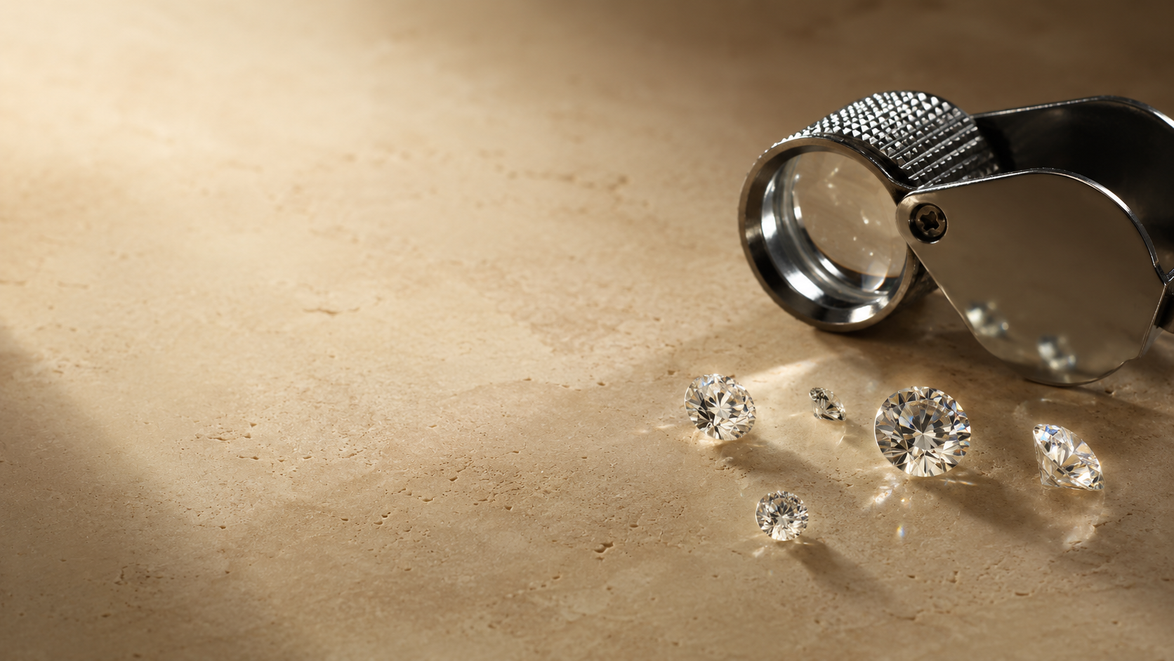 A jeweller's loupe beside loose stones for assessment