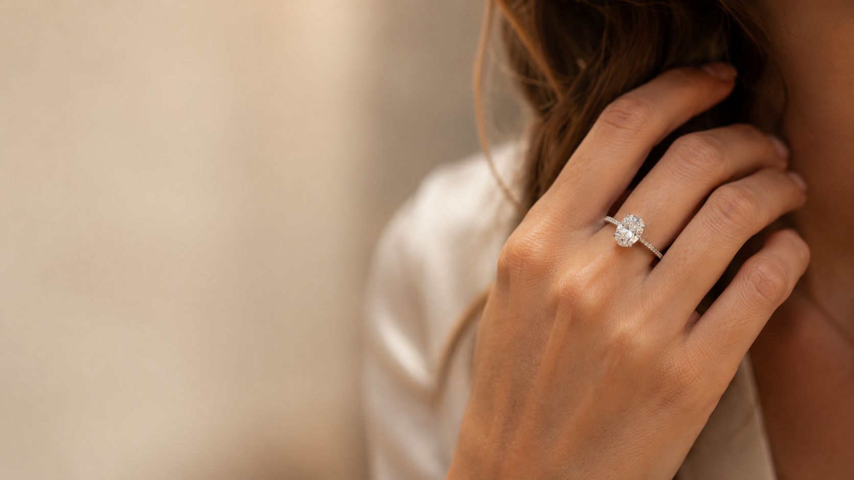 An oval diamond solitaire engagement ring worn on the hand