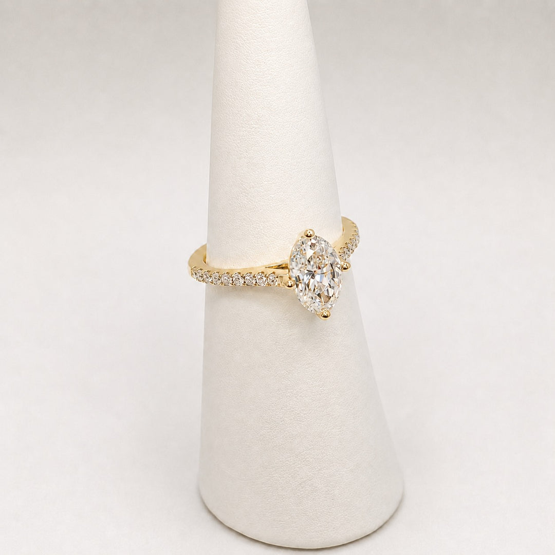 Oval solitaire engagement ring in 18ct yellow gold with a pave set band