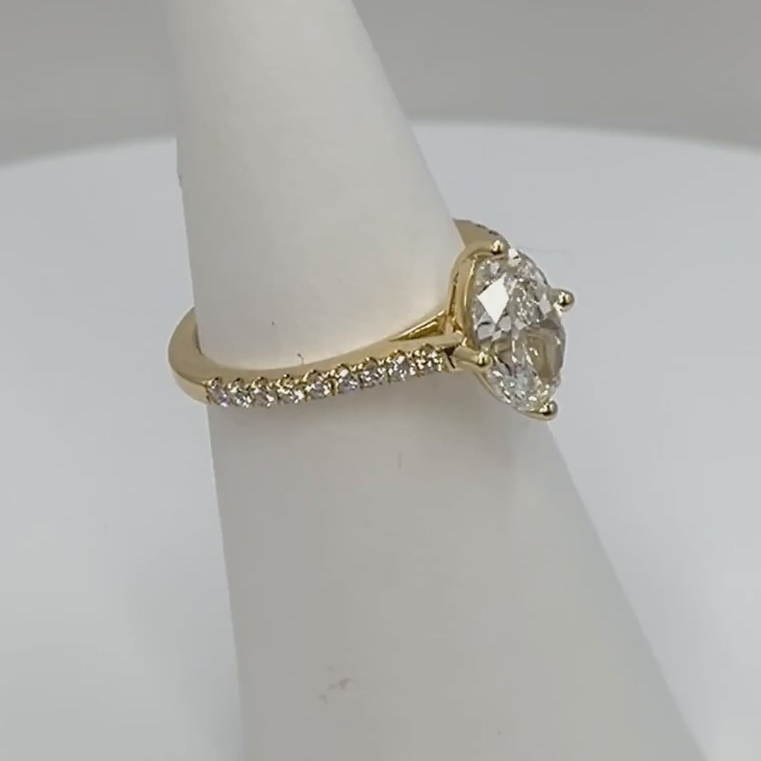 Oval diamond solitaire engagement ring in 18ct yellow gold rotating to show the diamond set shoulders